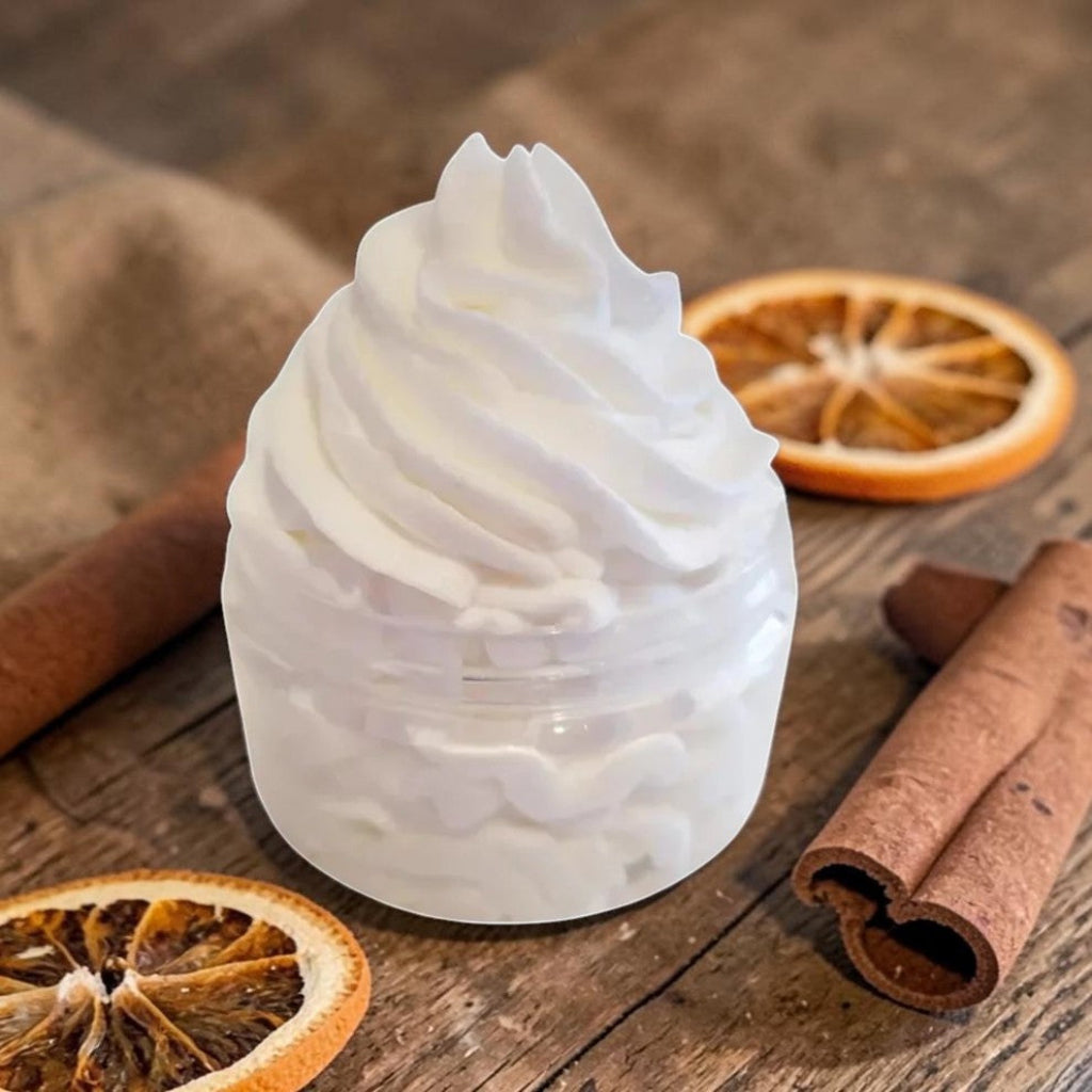 White whipped citrus body wash with citrus slices on a wooden surface
