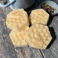Hexagonal honeycomb-shaped lotion bars on a wooden surface