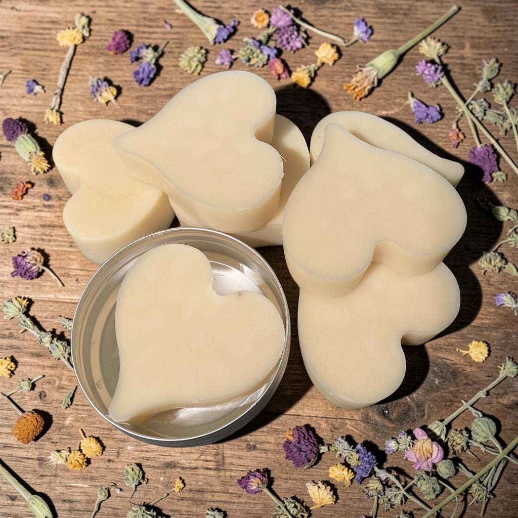 Heart-shaped lotion bar on a wooden surface with dried flowers