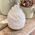 White whipped body cream with honey and shea butter -shaped object on a wooden surface with a blurred background