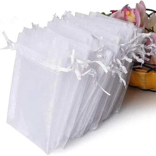 White organza bags with a basket of flowers in the background